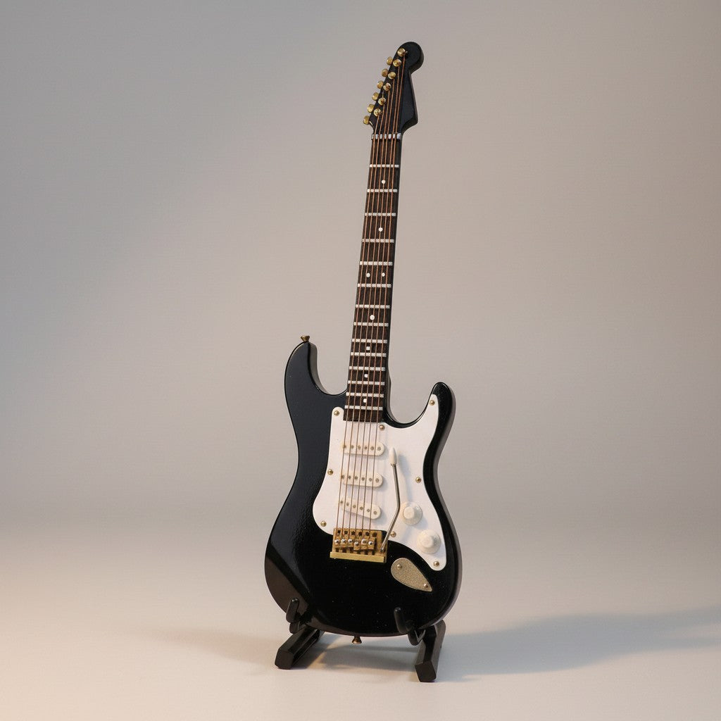 Regalos Ejecutivos Ortiz black electric guitar replica, 14cm, with white pickguard and gold hardware, on display stand.