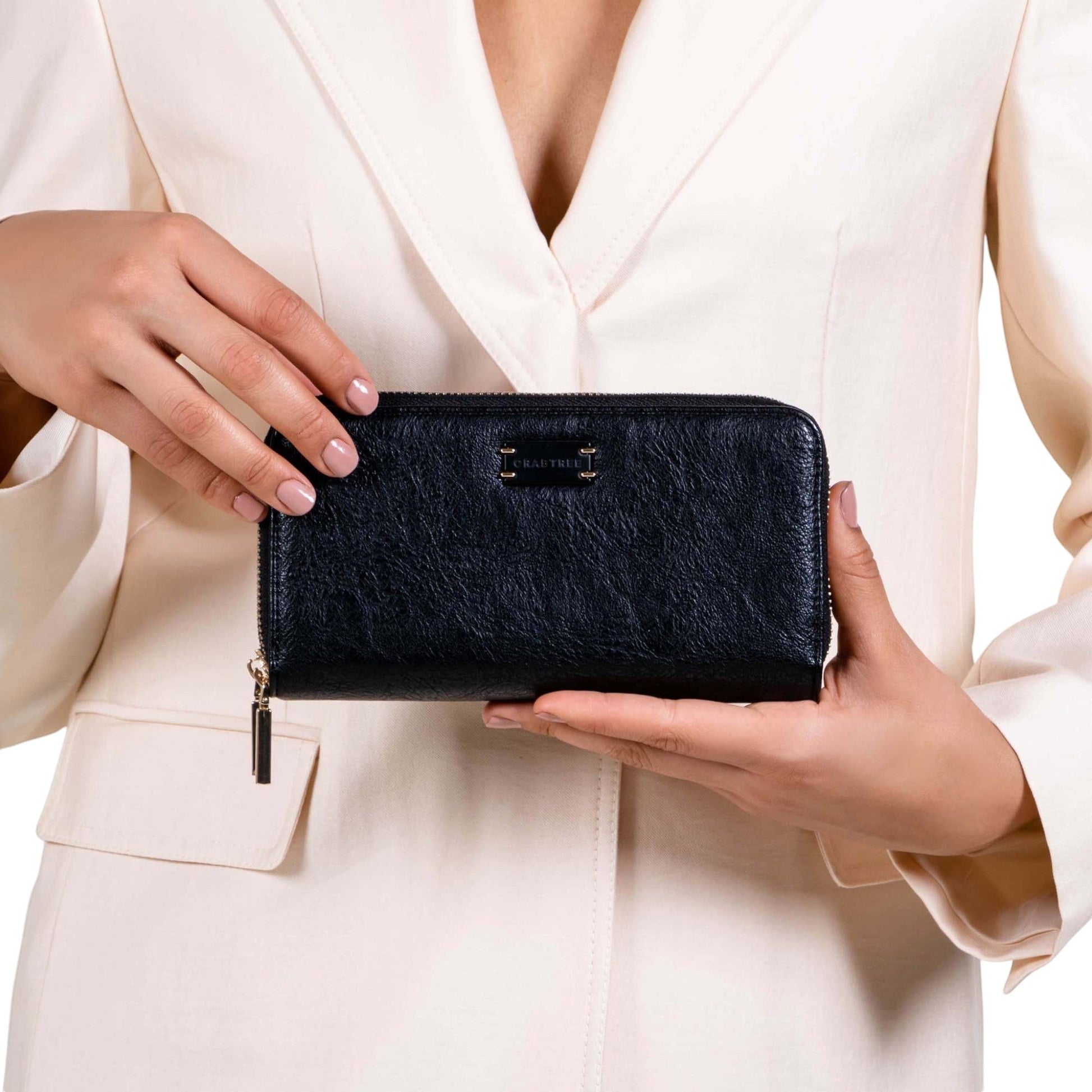 Regalos Ejecutivos Ortiz black textured leather wallet with double zipper and metal logo plaque.